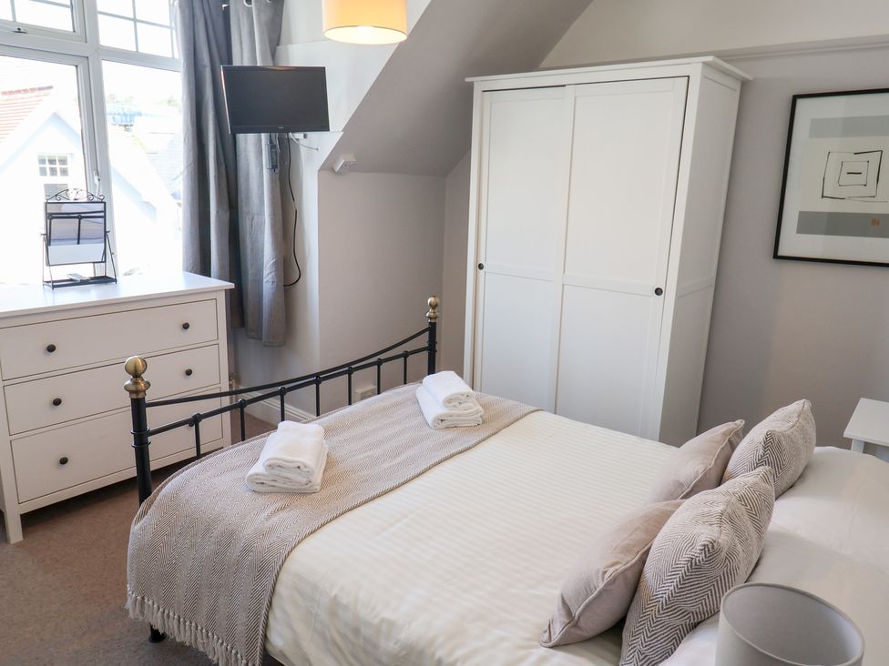 A bedroom with a bed and a wardrobe at Watersmeet in Lyme Regis
