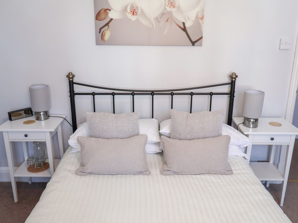 A bedroom with a bed and bedside tables at Watersmeet in Lyme Regis