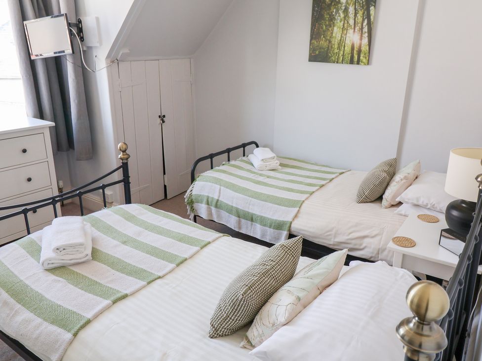 A bedroom with two beds and a bedside table at Watersmeet in Lyme Regis