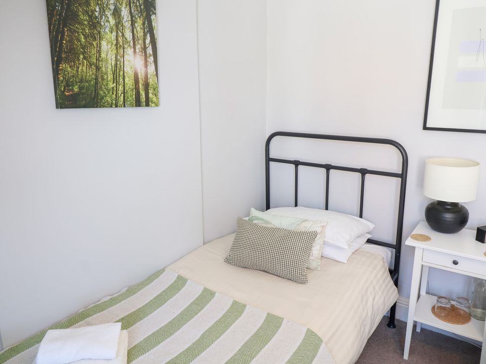 A bedroom with a bed and bedside table at Watersmeet Lyme Regis