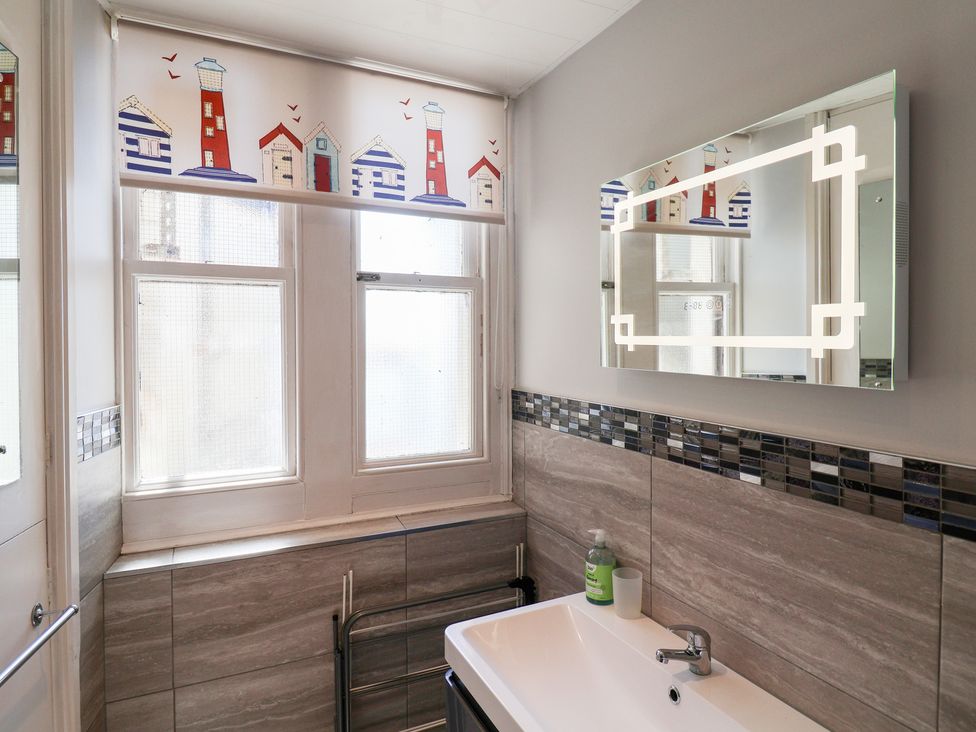 A bathroom with a wash basin and a mirror at Watersmeet in Lyme Regis