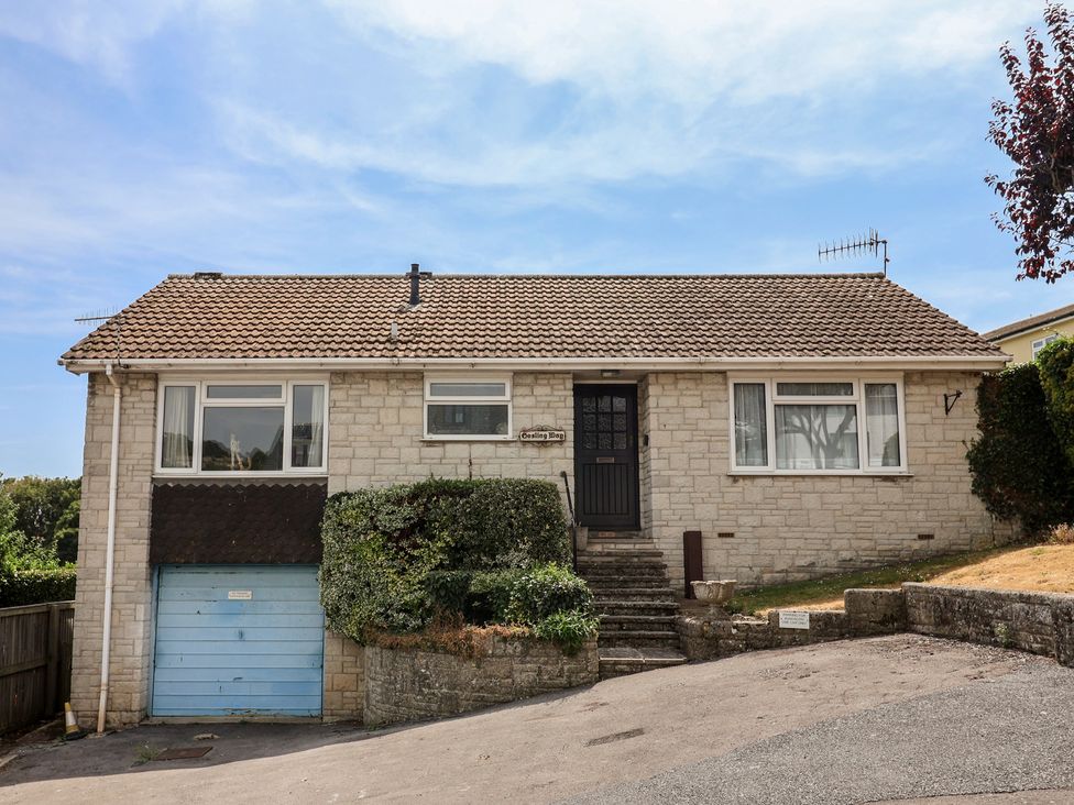 A house with a garage and landscaping at Gosling Way Lyme Regis