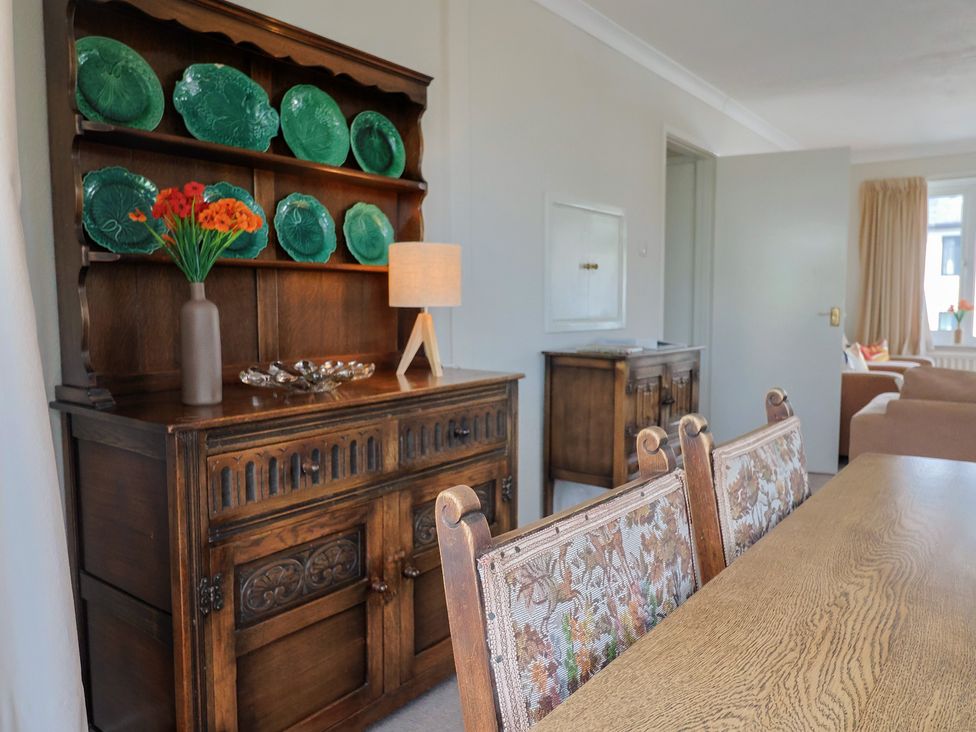 A dining room with a sideboard and decorative plates at Gosling Way in Lyme Regis