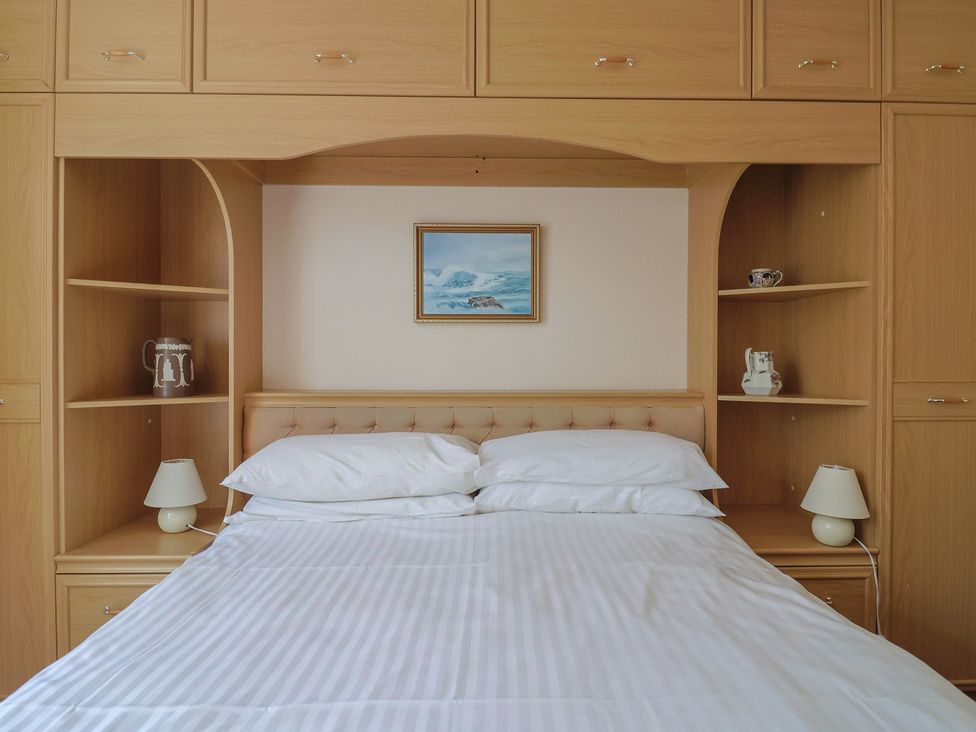 A bedroom with a bed and shelves at Gosling Way in Lyme Regis