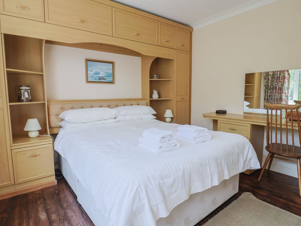 A bedroom with a bed and shelves at Gosling Way in Lyme Regis