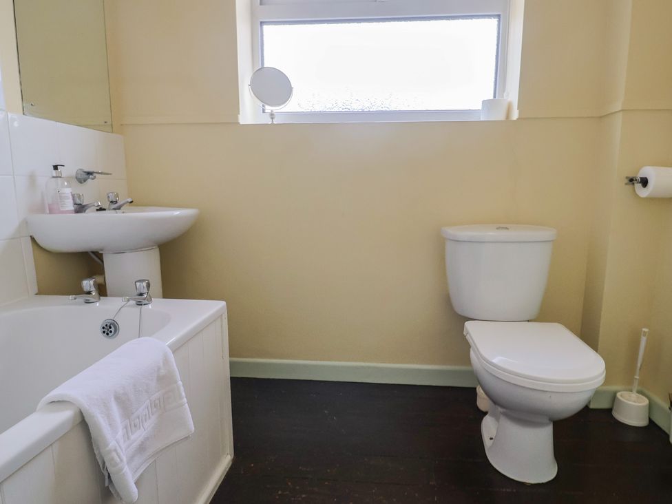 A bathroom with a bath, sink, and toilet at Gosling Way Lyme Regis
