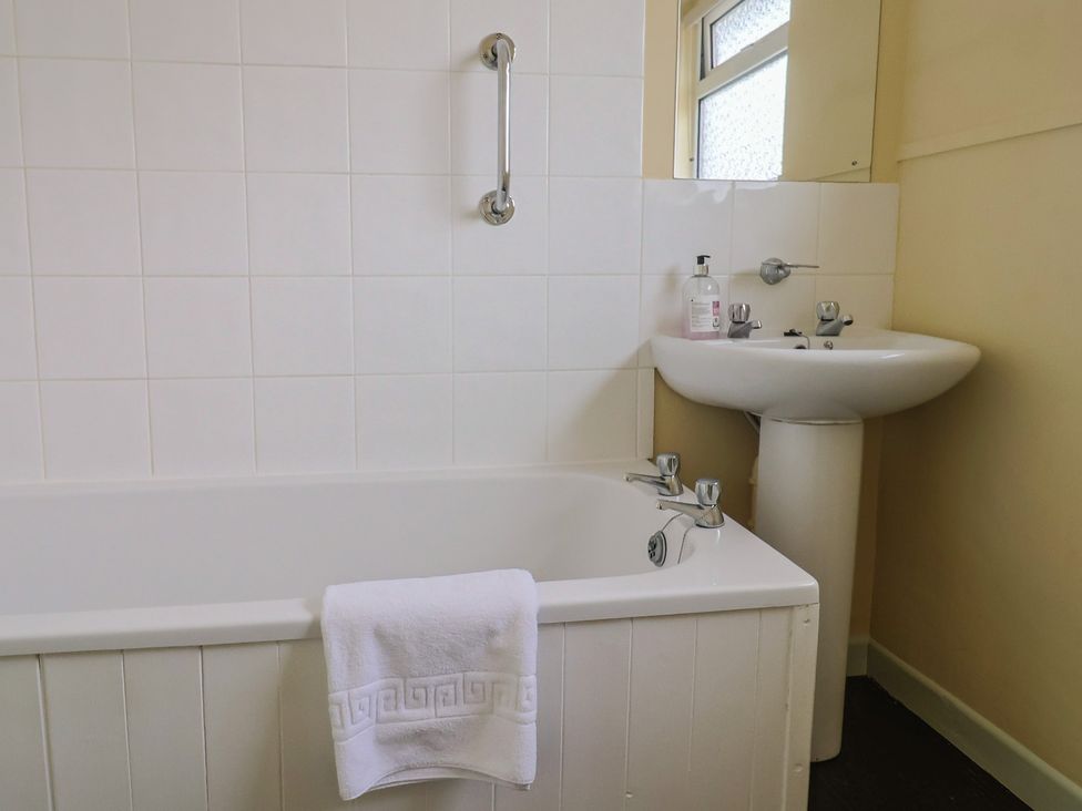 A bathroom featuring a bathtub and sink at Gosling Way in Lyme Regis