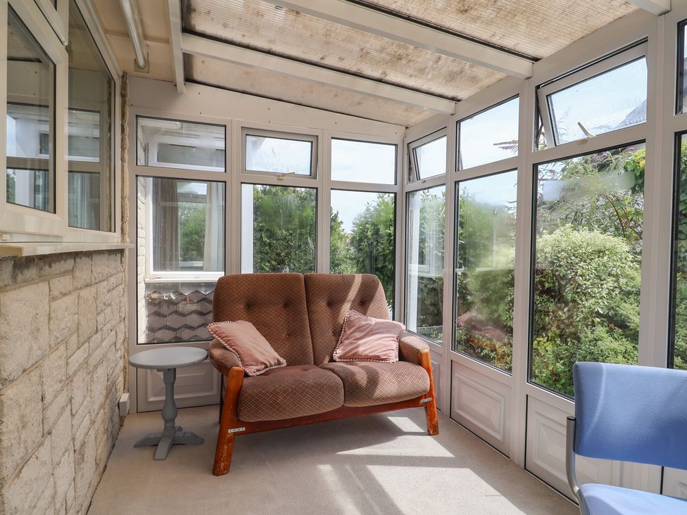 A conservatory with a sofa and side table at Gosling Way Lyme Regis