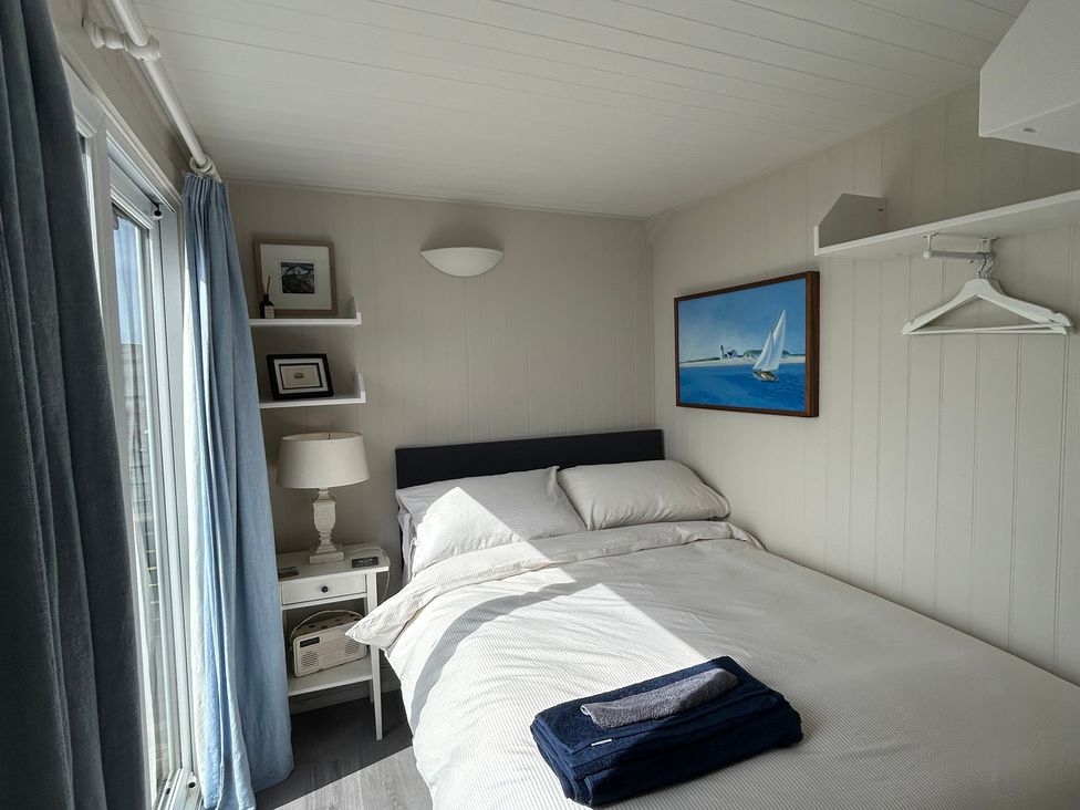 A bedroom with a bed and side table at 8 Bowling Green Chalets Lyme Regis