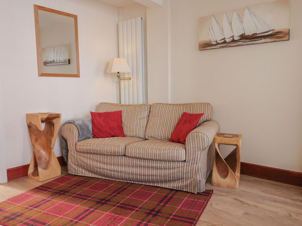 A living room with a sofa and side tables at 3 Dolphin Cottages Lyme Regis