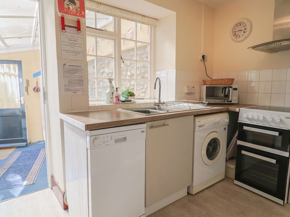 A kitchen with appliances including a dishwasher, washing machine and microwave at 3 Dolphin Cottages, Lyme Regis