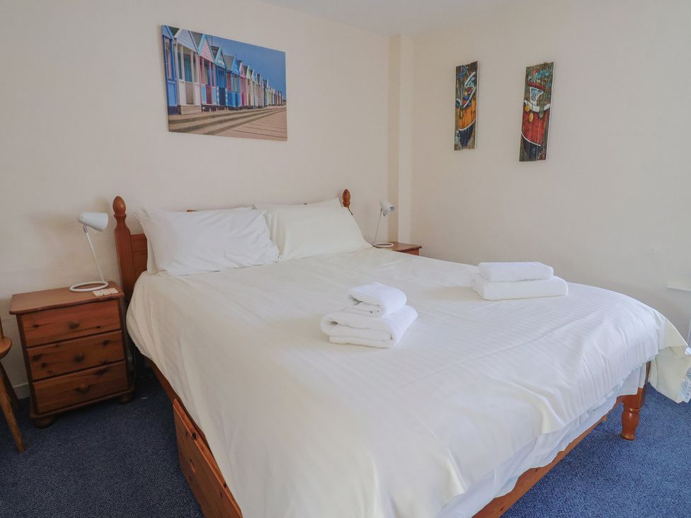 A bedroom with a bed and bedside table at 3 Dolphin Cottages in Lyme Regis