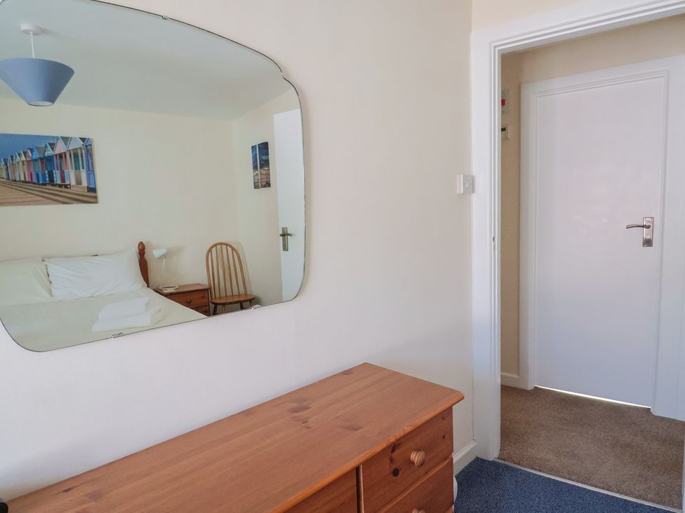 A bedroom with a bed and dresser at 3 Dolphin Cottages in Lyme Regis