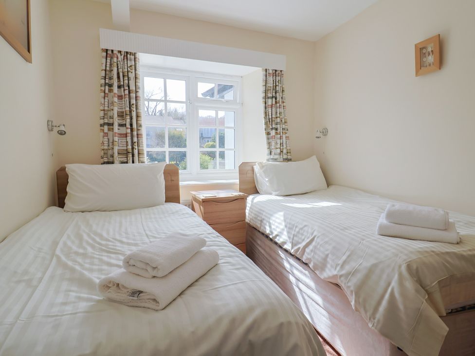 A bedroom with two single beds and a nightstand at 3 Dolphin Cottages in Lyme Regis