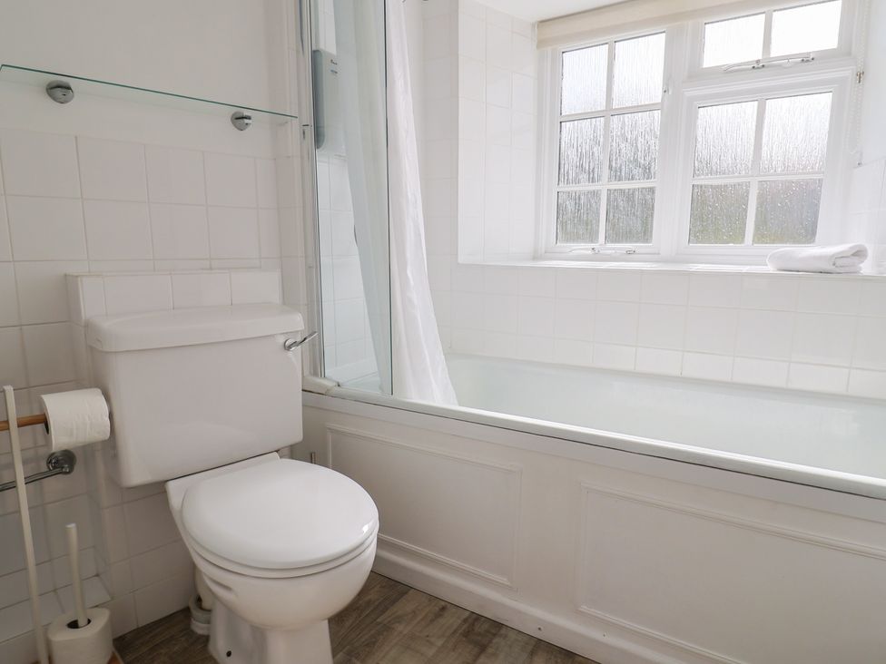 A bathroom with a toilet and bathtub at 3 Dolphin Cottages Lyme Regis