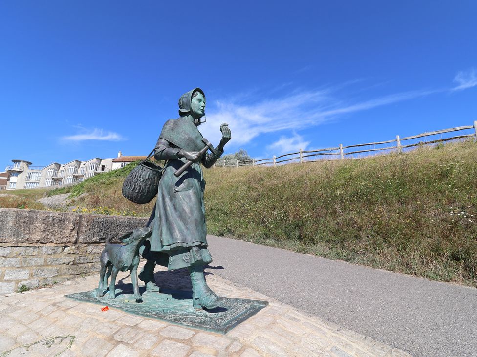 A statue of a woman with a dog and a basket at 3 Dolphin Cottages in Lyme Regis