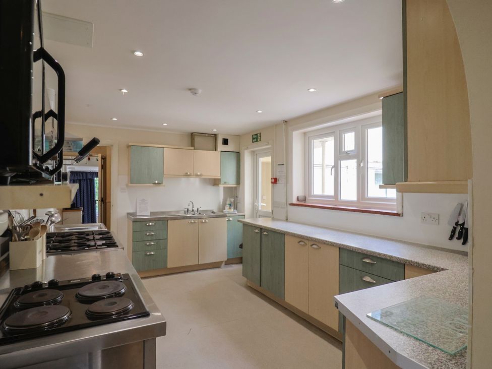 A kitchen with cabinets and a stove at The Orchard Country House Rousdon