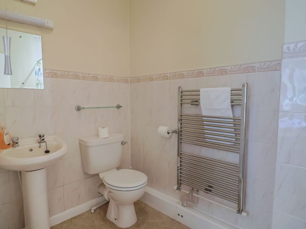 A bathroom with toilet, sink and towel rail at The Orchard Country House in Rousdon