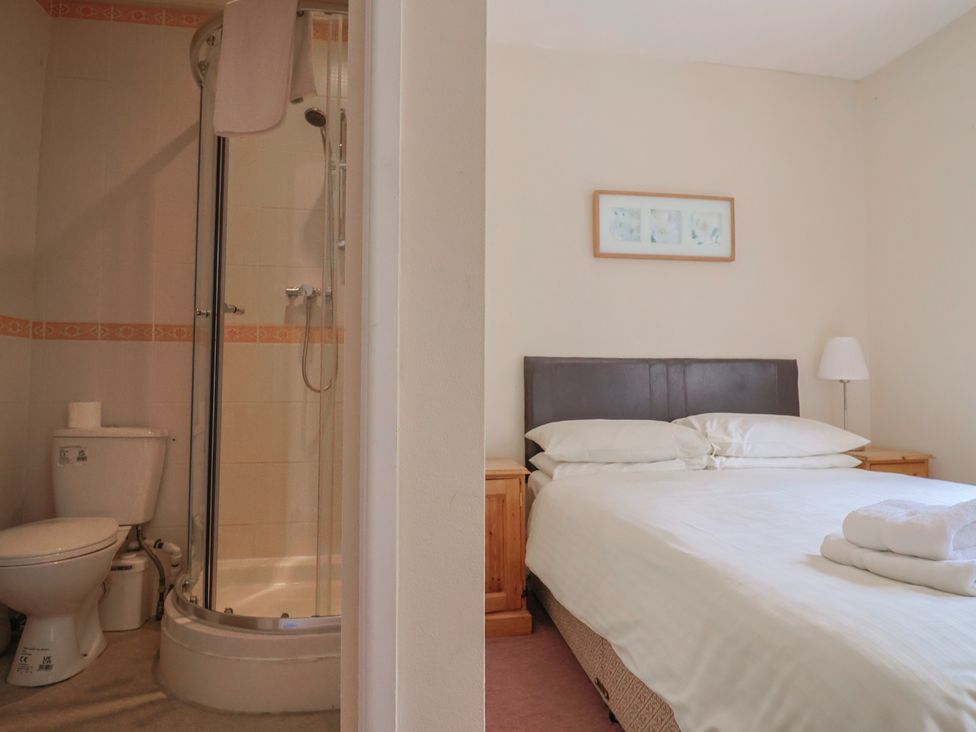A bedroom with a bed and a shower area at The Orchard Country House in Rousdon