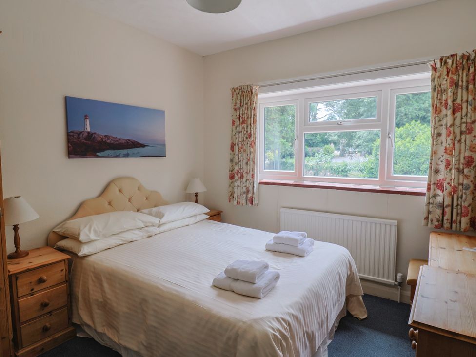 A bedroom with a bed and nightstands at The Orchard Country House in Rousdon