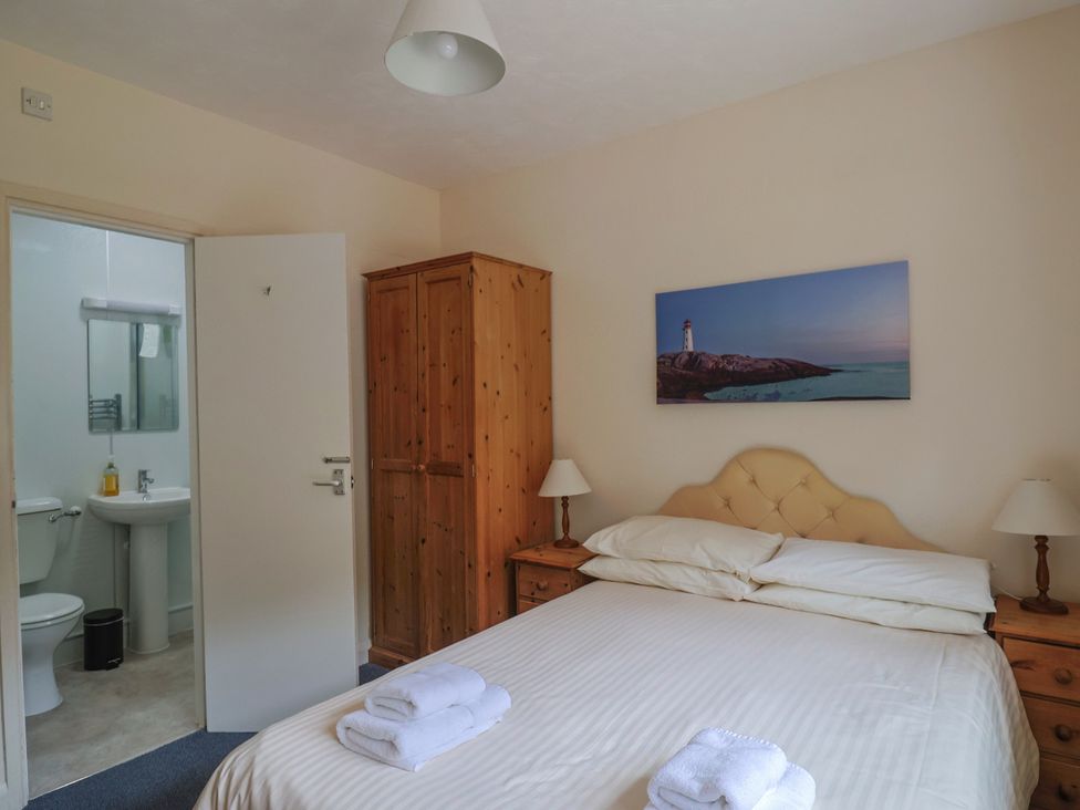 A bedroom with a double bed and an en-suite bathroom at The Orchard Country House in Rousdon