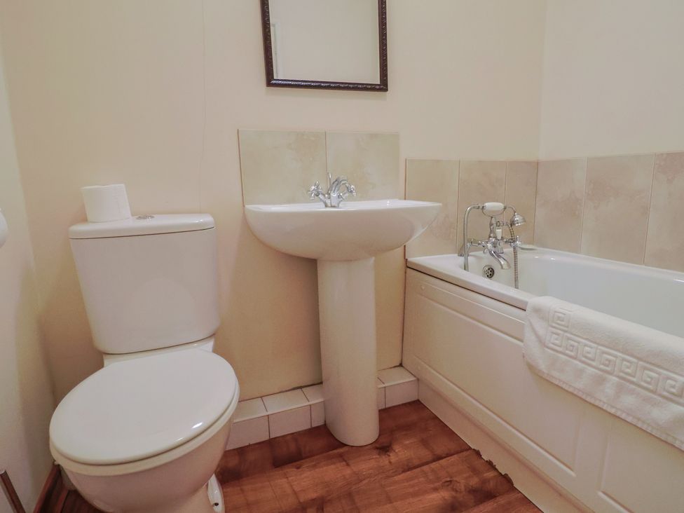 A bathroom with a sink, toilet, and a bathtub at The Orchard Country House in Rousdon