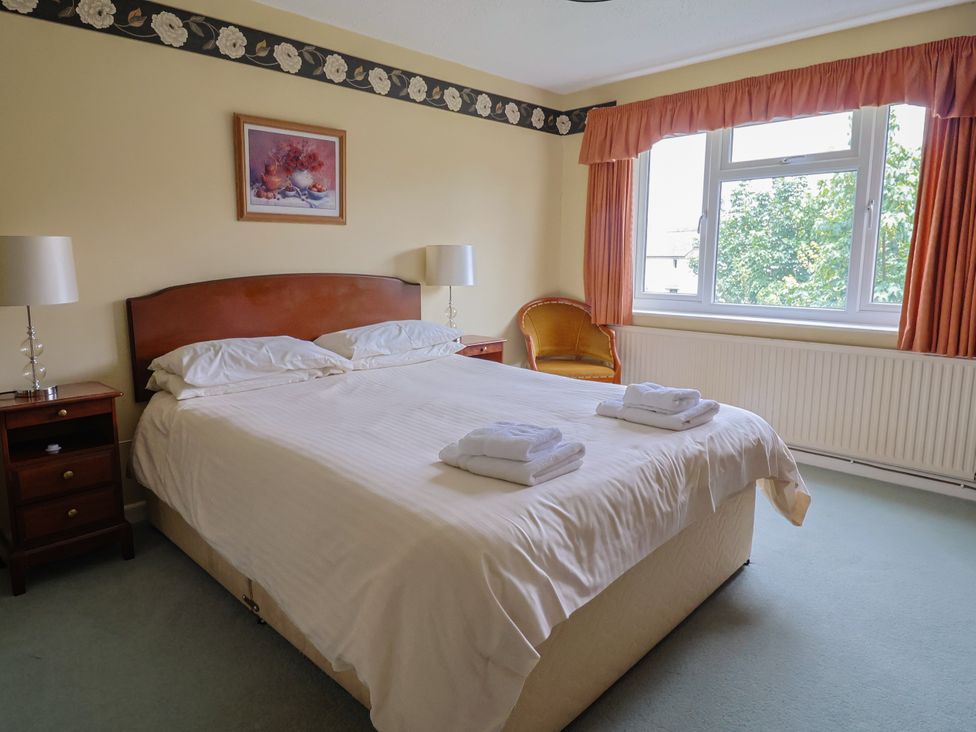 A bedroom with a bed, bedside table and chair at The Orchard Country House Rousdon