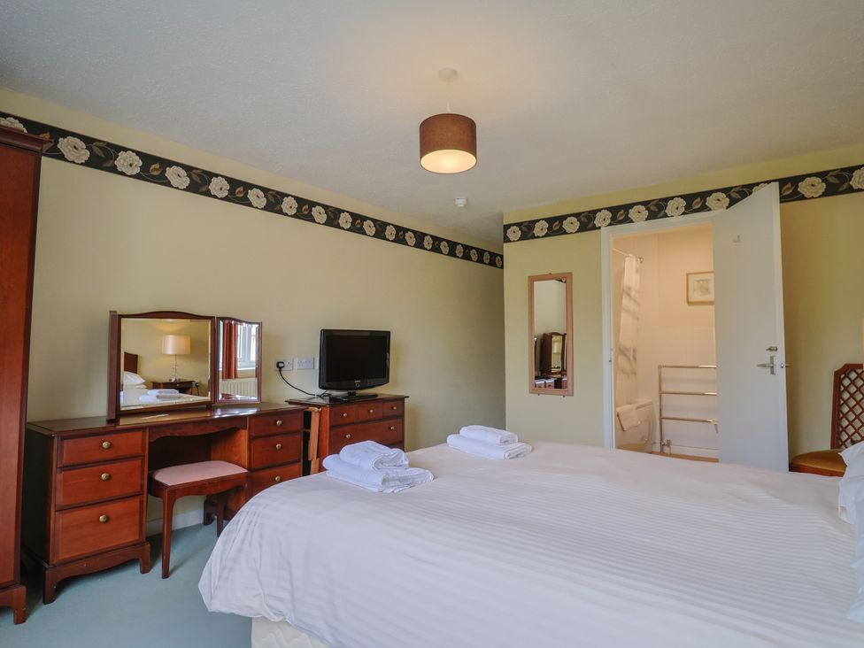 A bedroom with two beds and a television at The Orchard Country House Rousdon