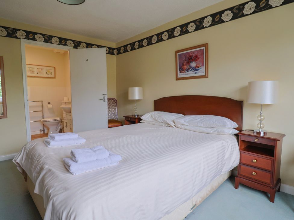 A bedroom with a bed and a nightstand at The Orchard Country House in Rousdon