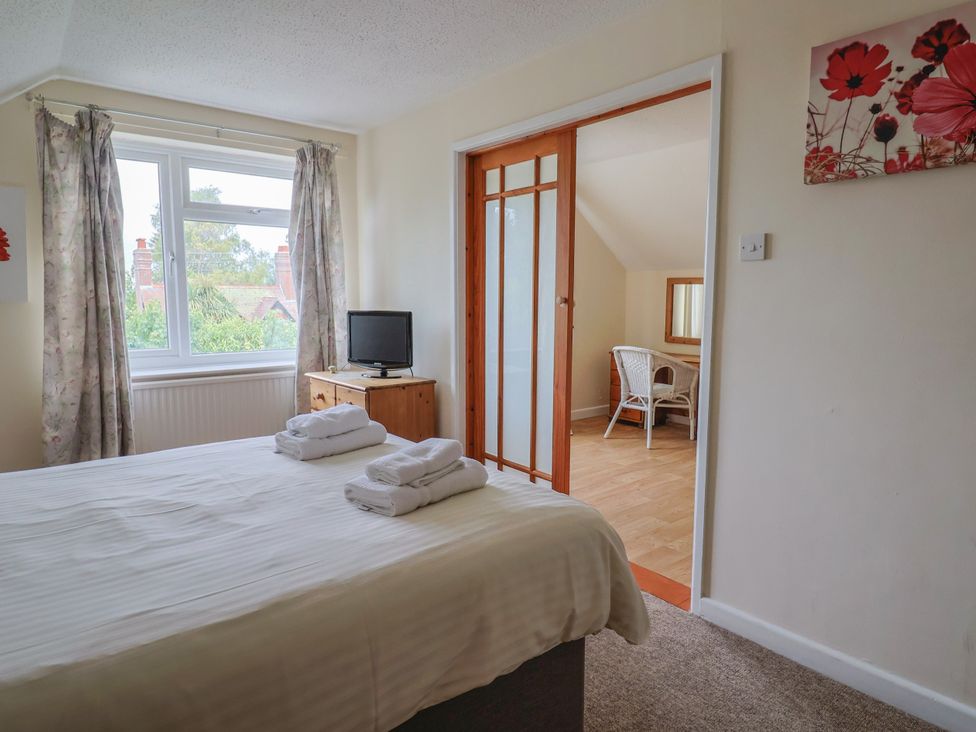 A bedroom with a bed and a television at The Orchard Country House Rousdon