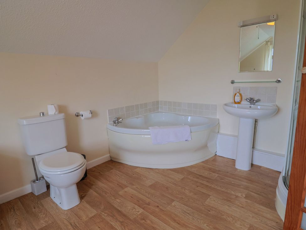 A bathroom with a bath, toilet, and sink at The Orchard Country House Rousdon