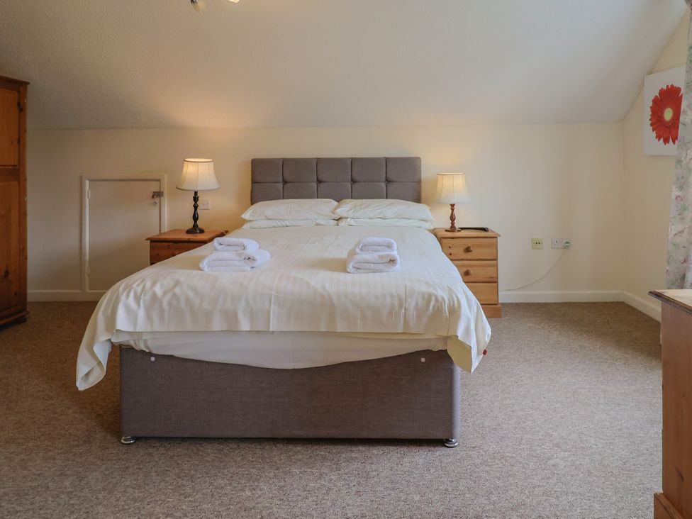 A bedroom with a bed and two lamps at The Orchard Country House in Rousdon