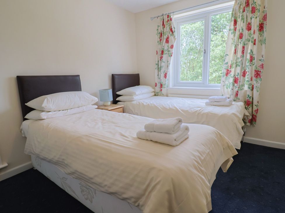 A bedroom with two beds and a window at The Orchard Country House in Rousdon