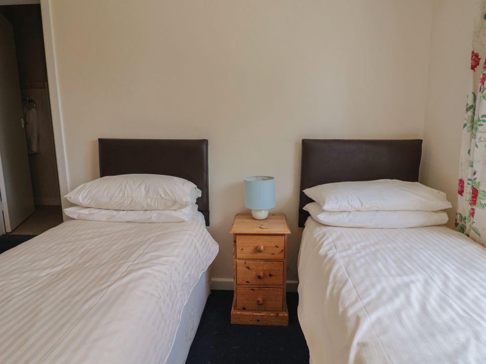 A bedroom with two beds separated by a nightstand at The Orchard Country House in Rousdon