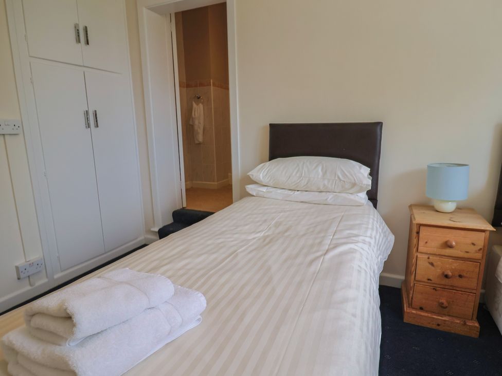 A bedroom with a single bed and towels at The Orchard Country House in Rousdon