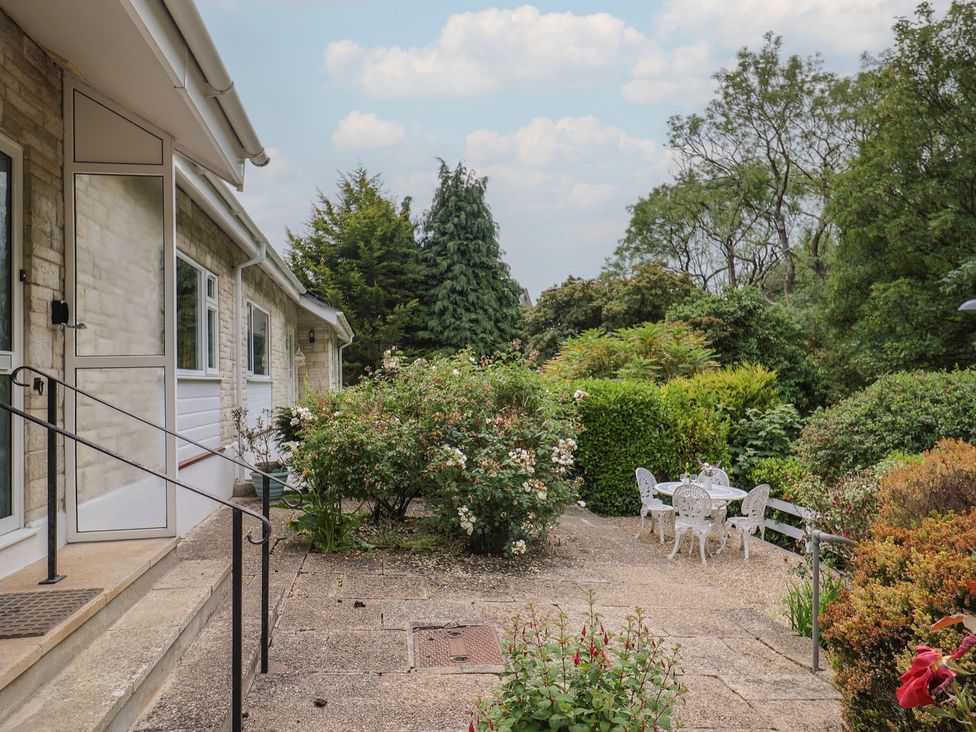 A garden with a table and chairs at High Trees Lyme Regis