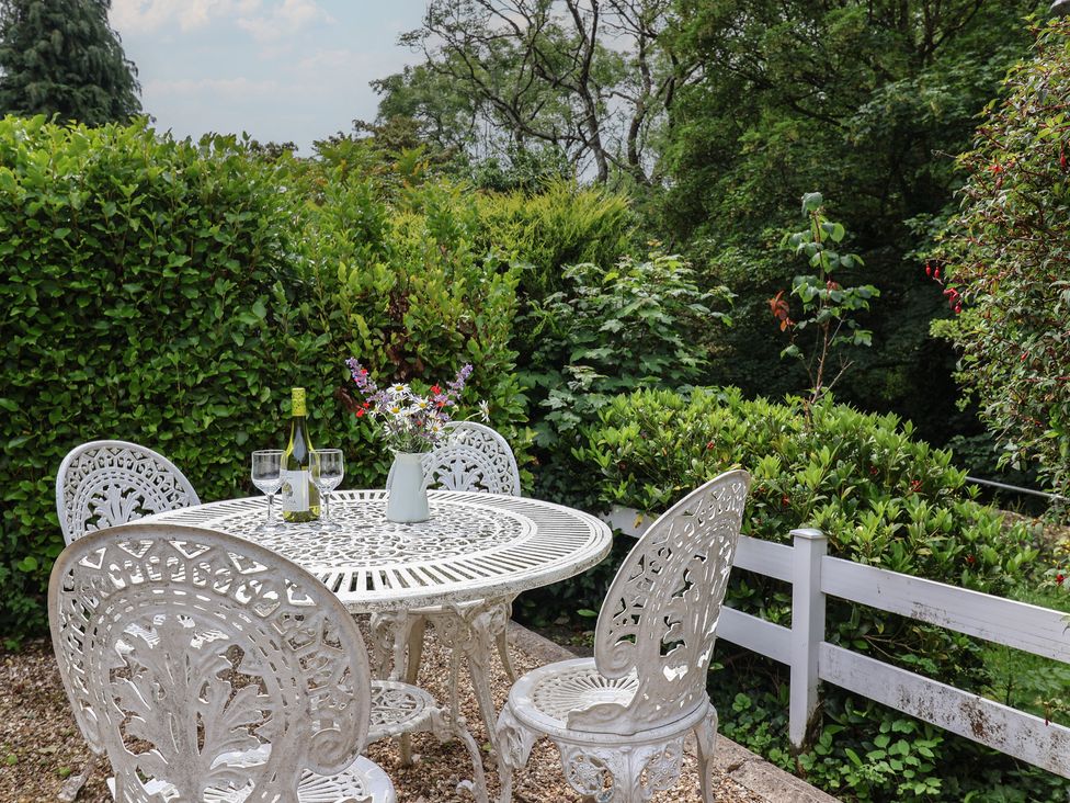 A garden with a table and chairs set at High Trees in Lyme Regis