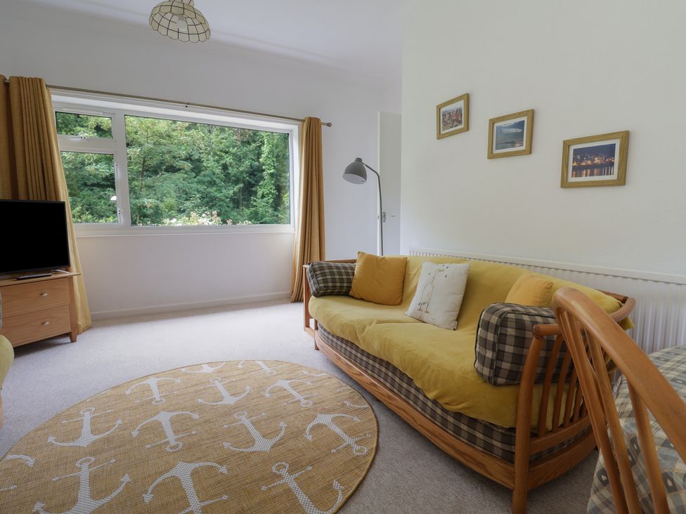 A living room with a sofa and television at High Trees in Lyme Regis
