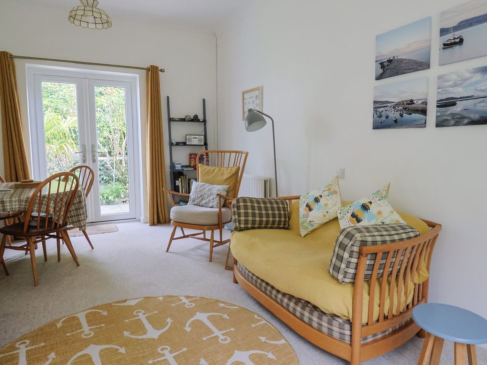A living room with a sofa and dining table at High Trees in Lyme Regis