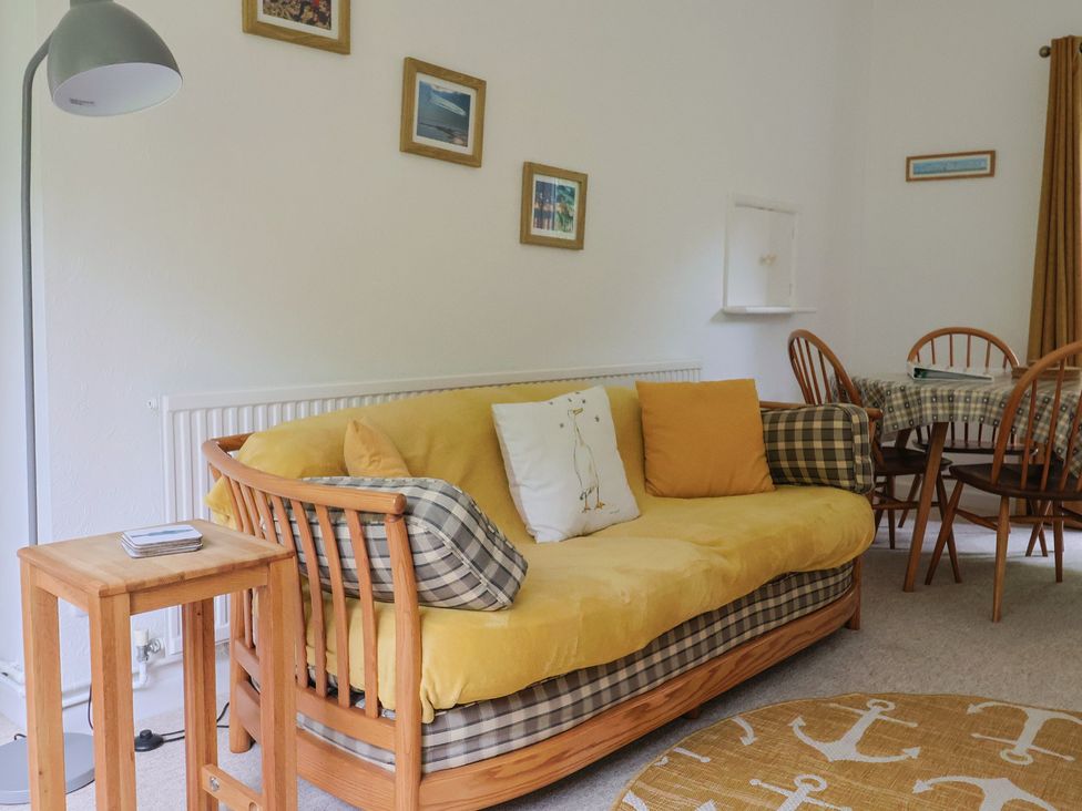 A living room with a sofa and dining table at High Trees in Lyme Regis