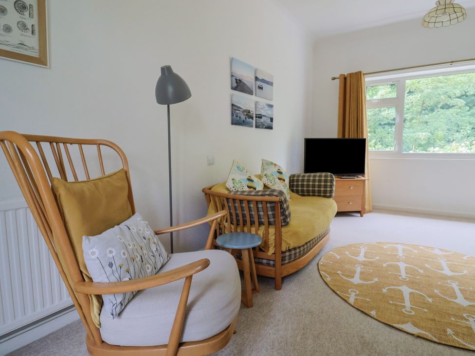 A living room with a sofa and a TV at High Trees in Lyme Regis