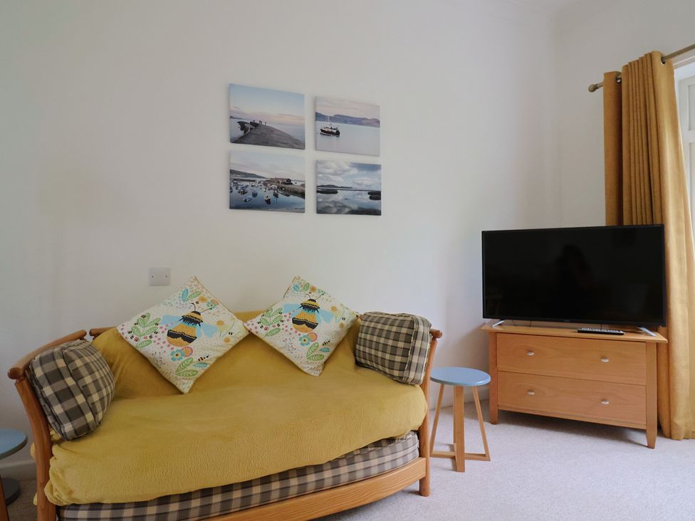 A living room with a sofa and TV at High Trees in Lyme Regis