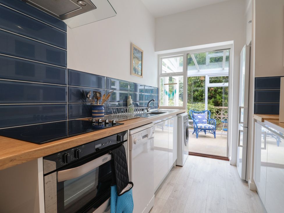 A kitchen with a stove and dishwasher at High Trees in Lyme Regis