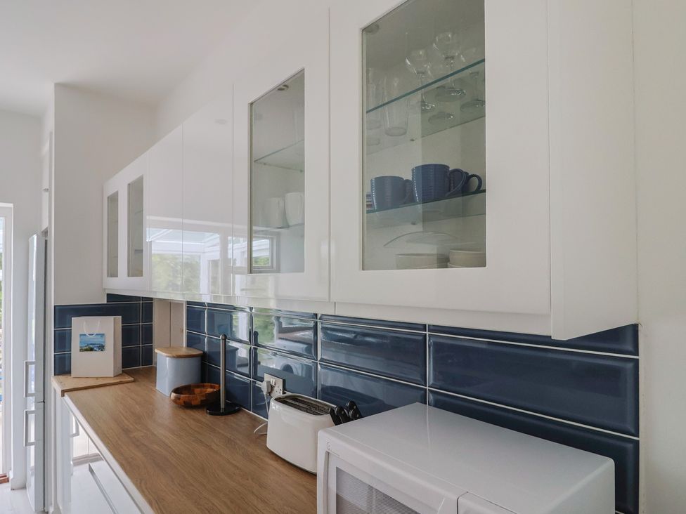 A kitchen with cabinets and appliances at High Trees in Lyme Regis