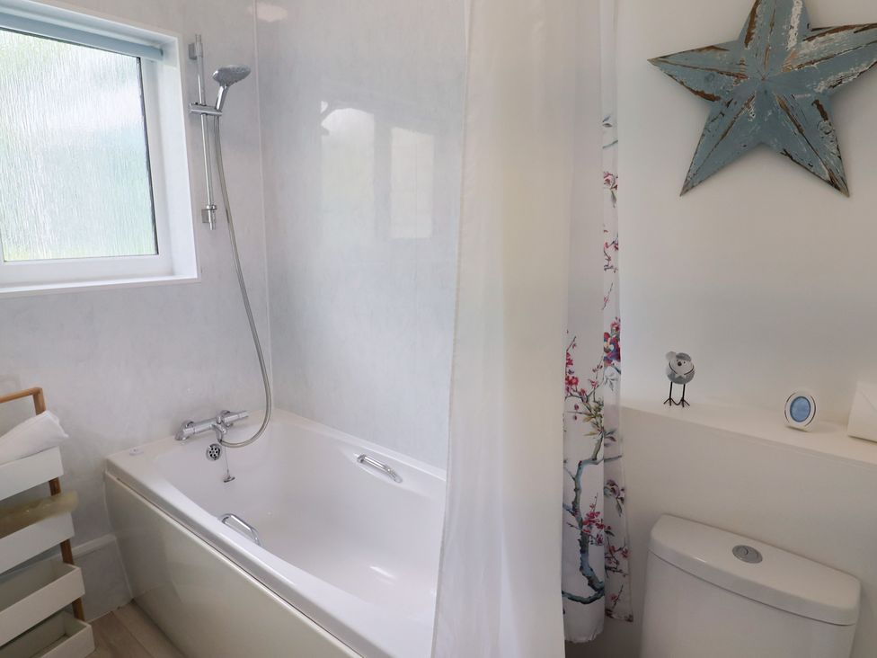 A bathroom with bathtub and shower at High Trees in Lyme Regis