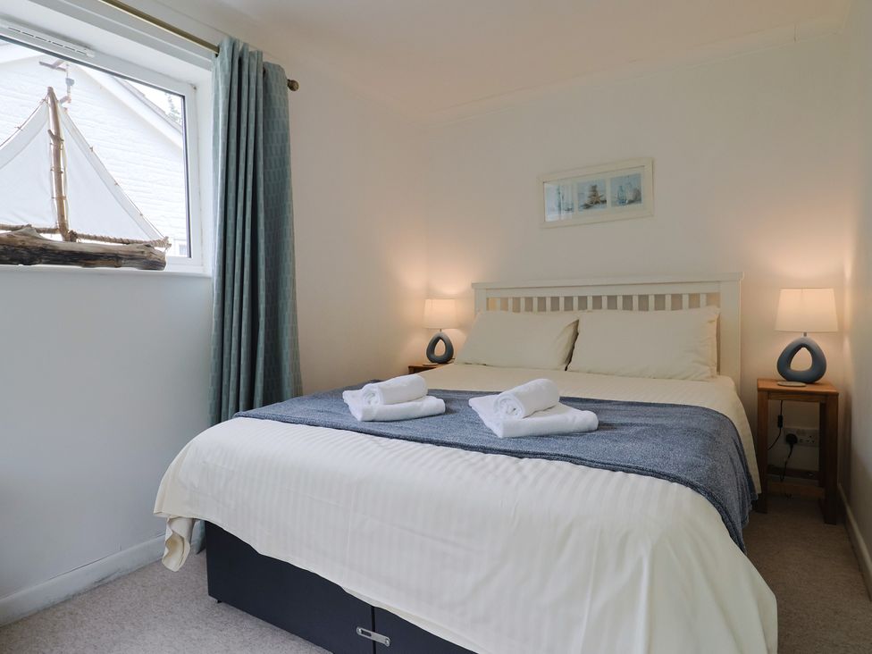 A bedroom with a bed and two lamps at High Trees in Lyme Regis