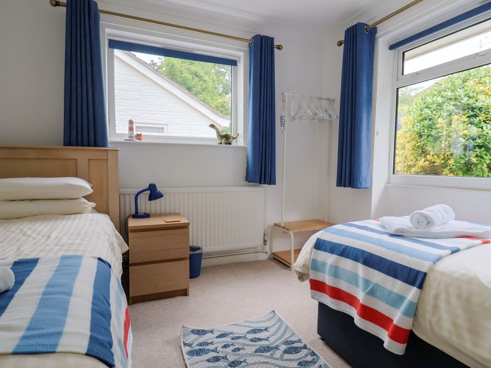 A bedroom with two beds and a window at High Trees in Lyme Regis