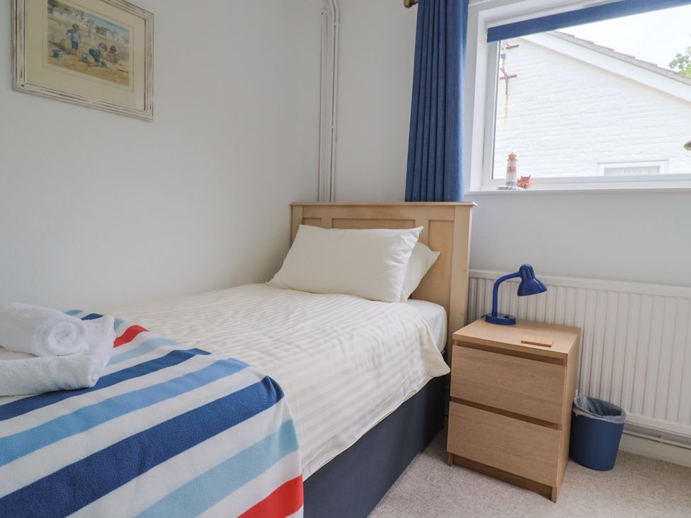 A bedroom with a single bed and bedside table at High Trees in Lyme Regis