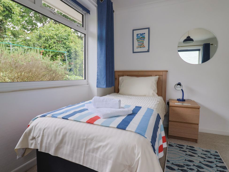 A bedroom with bed and nightstand at High Trees in Lyme Regis