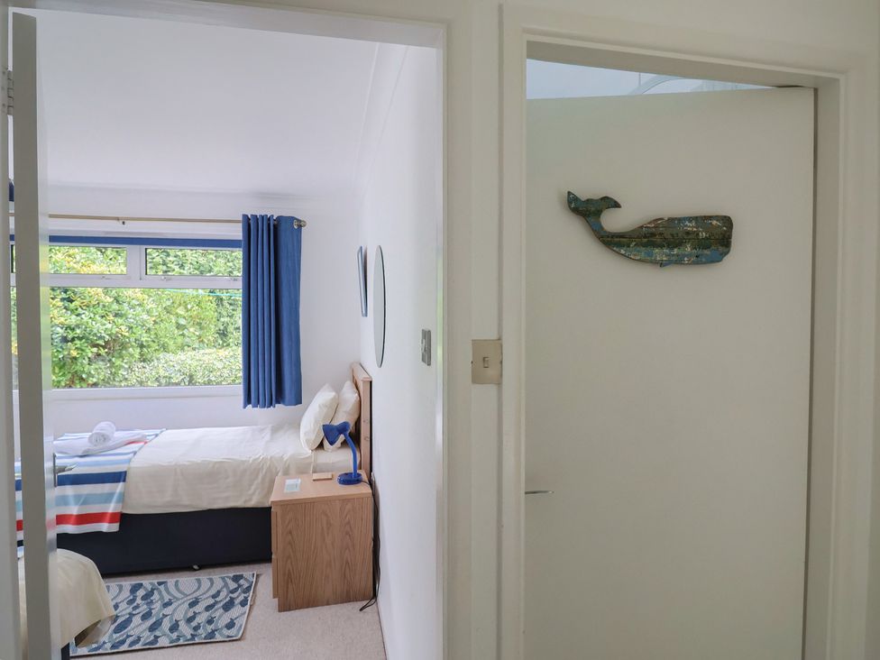 A bedroom featuring a bed and window at High Trees in Lyme Regis